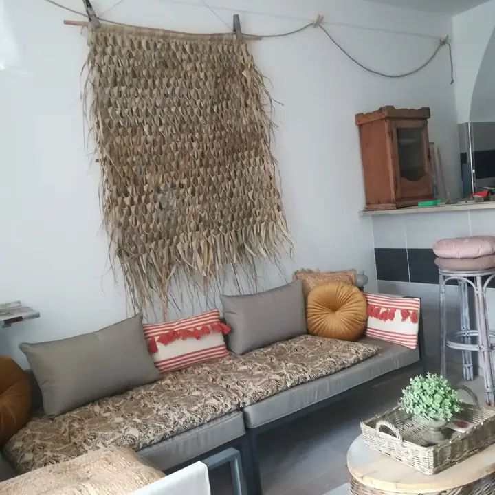 Salon et banquette sous la tenture végétale — La Lavandière, hébergement Bed in Shop à Romans-sur-Isère