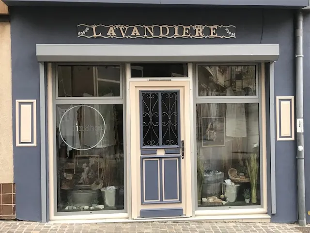 La devanture bleu-gris de l’ancienne boutique La Lavandière à Romans-sur-Isère